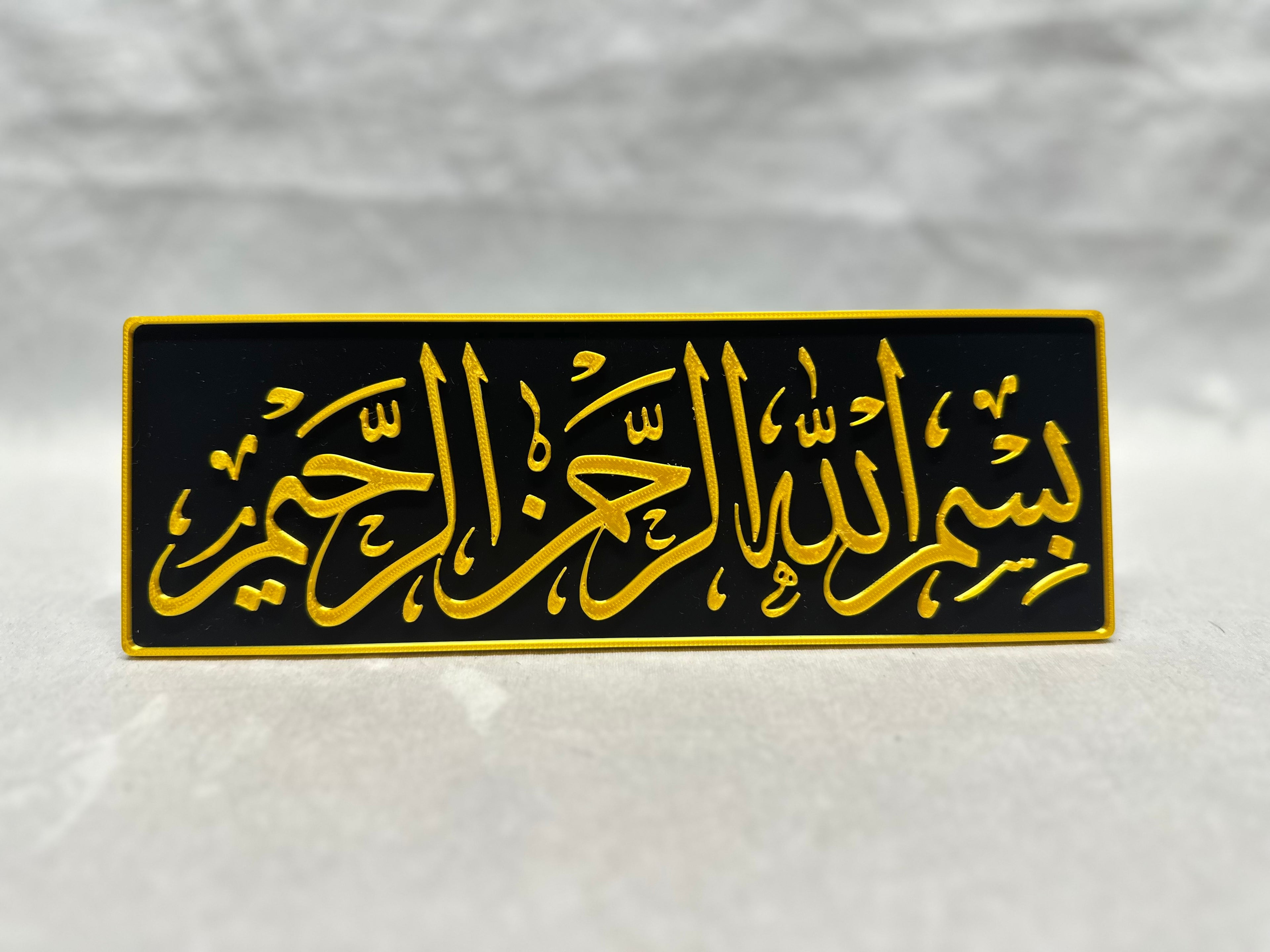 Gold raised Arabic calligraphy of Bismillah Rahman Rahim on black panel