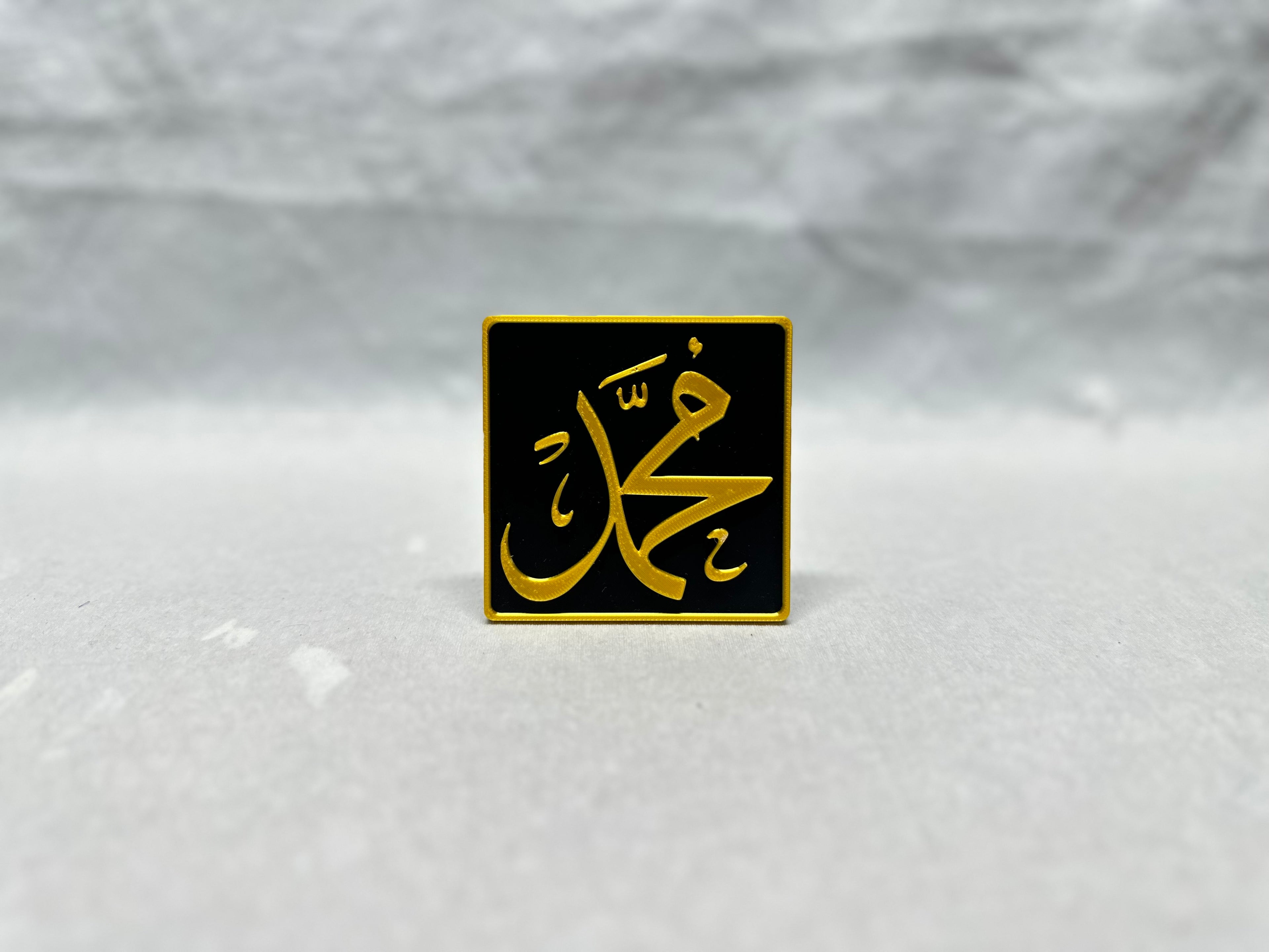 Gold raised Arabic calligraphy of Muhammad on black panel