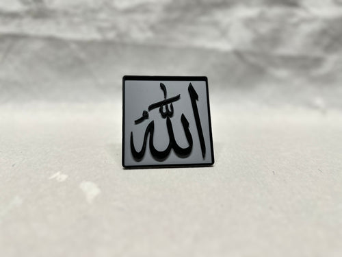 Black raised Arabic calligraphy of Allah on gray panel