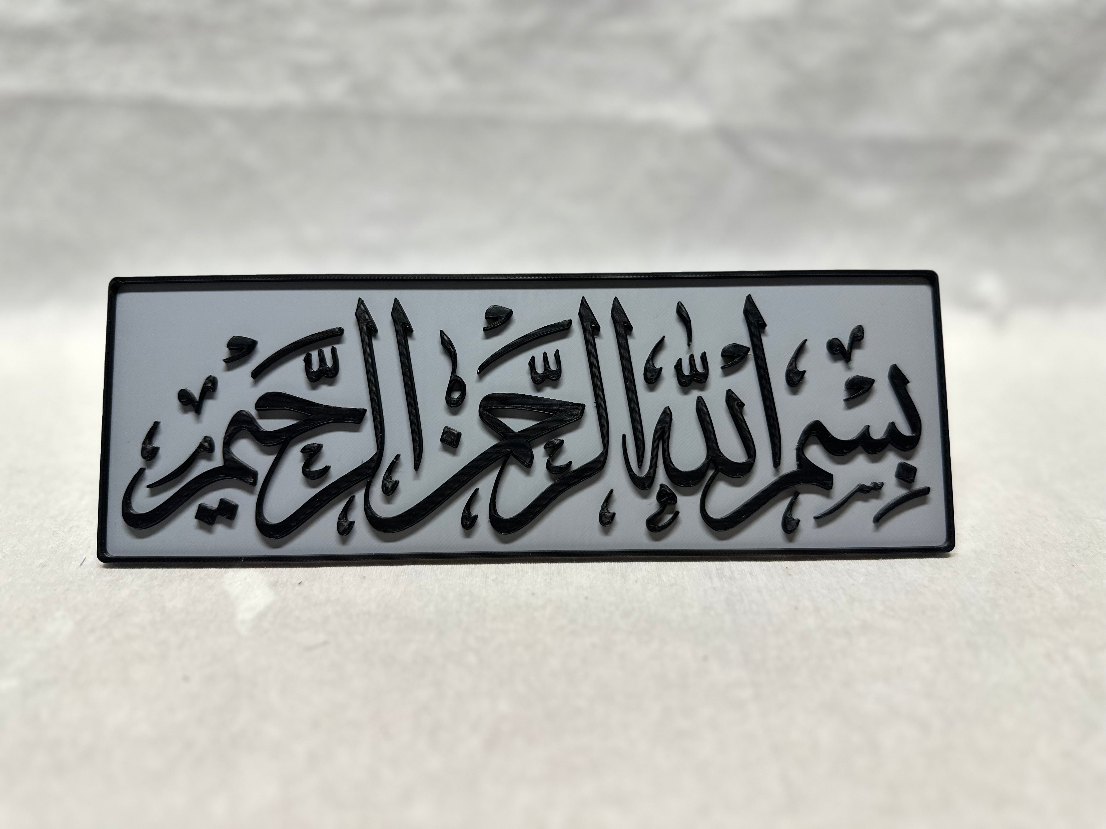 Black raised Arabic calligraphy of Bismillah Rahman Rahim on gray panel