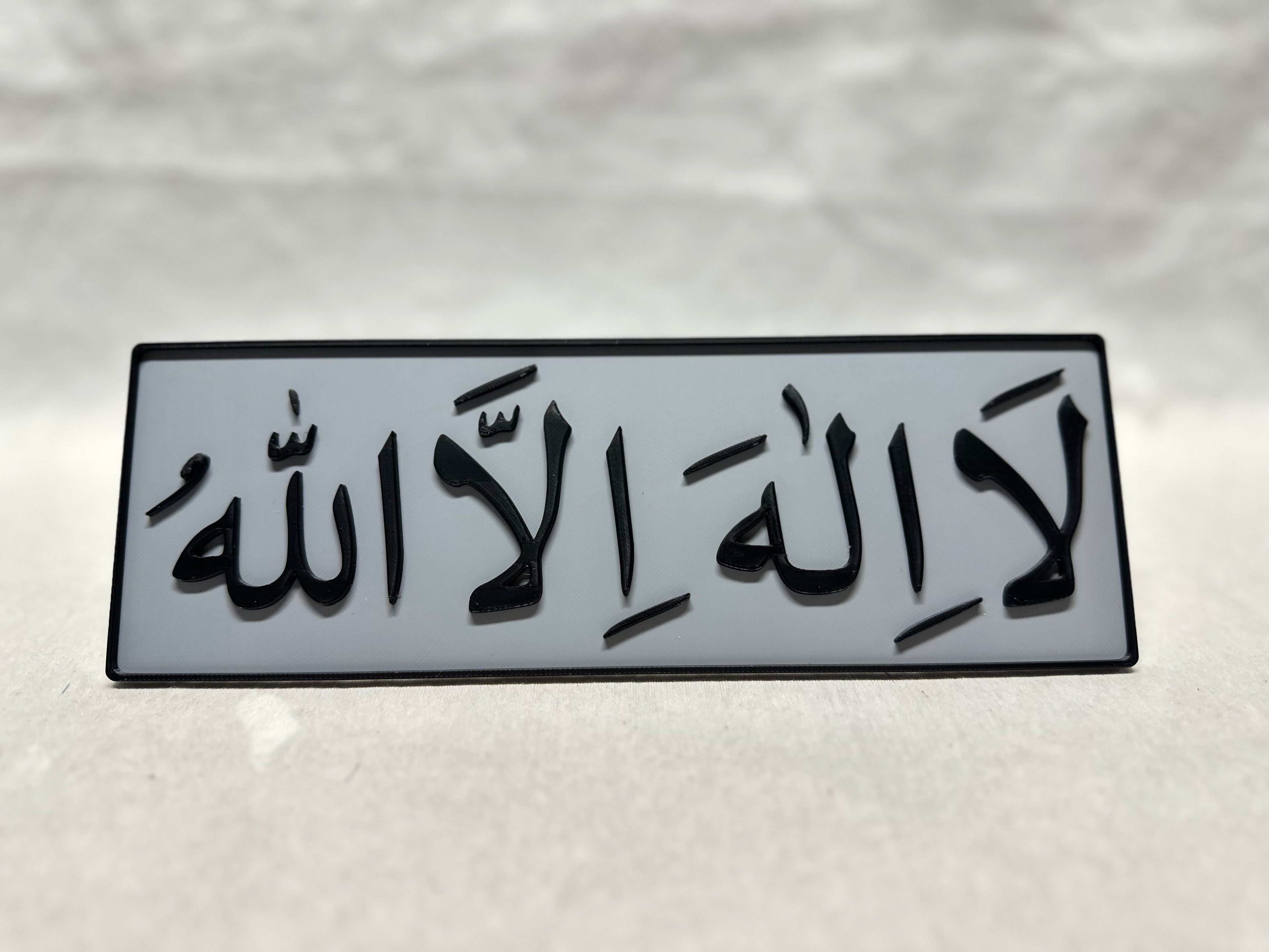Black raised Arabic calligraphy of Lailahaillallah on gray panel